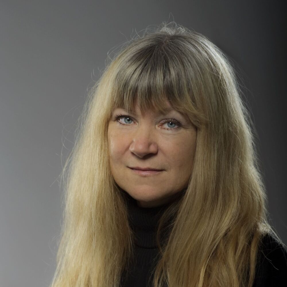 en kvinna med ljusa långa hår och en svart tröja