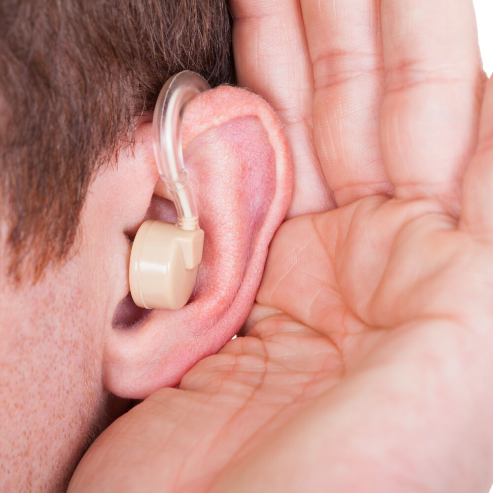 Foto Mostphotos 6405713-man-wearing-hearing-aid-and-listening-for-a-quiet-sound