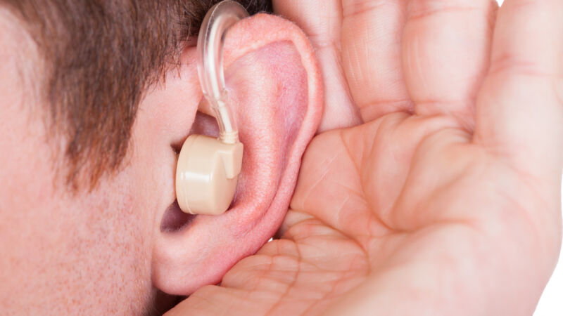 Foto Mostphotos 6405713-man-wearing-hearing-aid-and-listening-for-a-quiet-sound