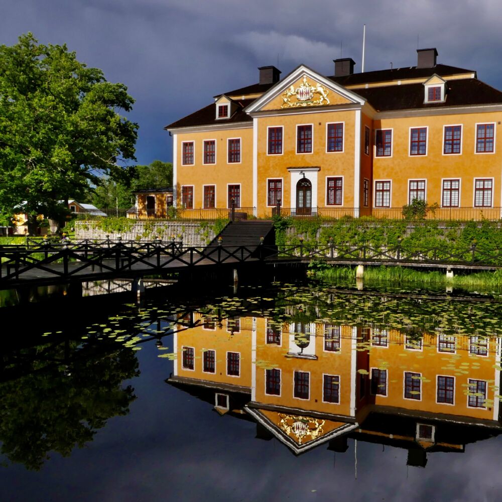 Lövstabruk herrgård, ett gult gård med trädgård.