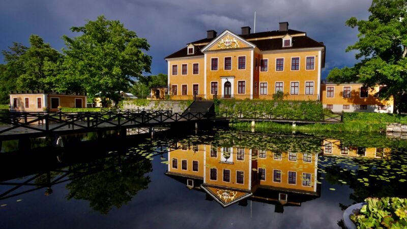 Lövstabruk herrgård, ett gult gård med trädgård.