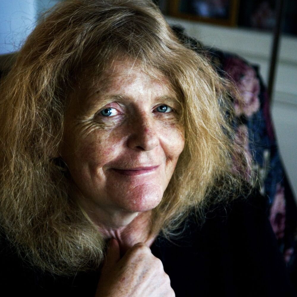 en äldre kvinna i svart blus och ljusa hår