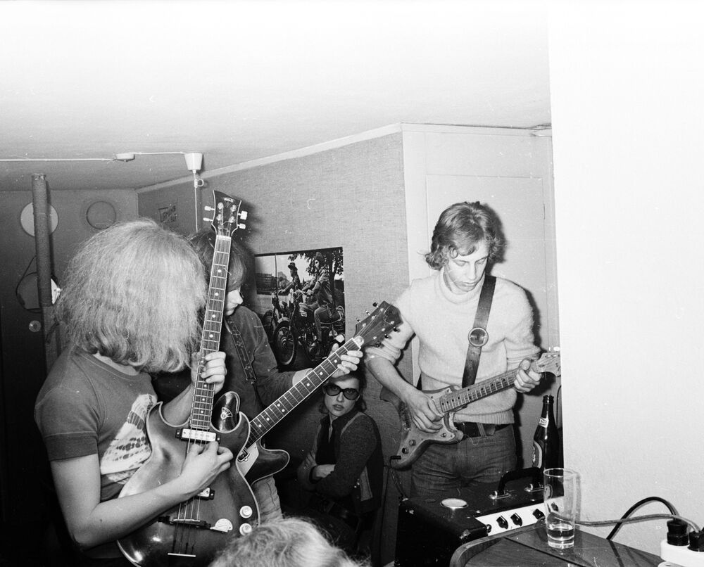 svart vit bild på en musikband med gitarr