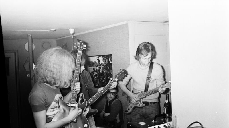 svart vit bild på en musikband med gitarr
