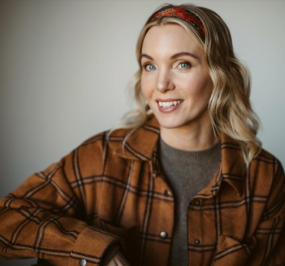 en blond kvinna i en brun-gul skjorta