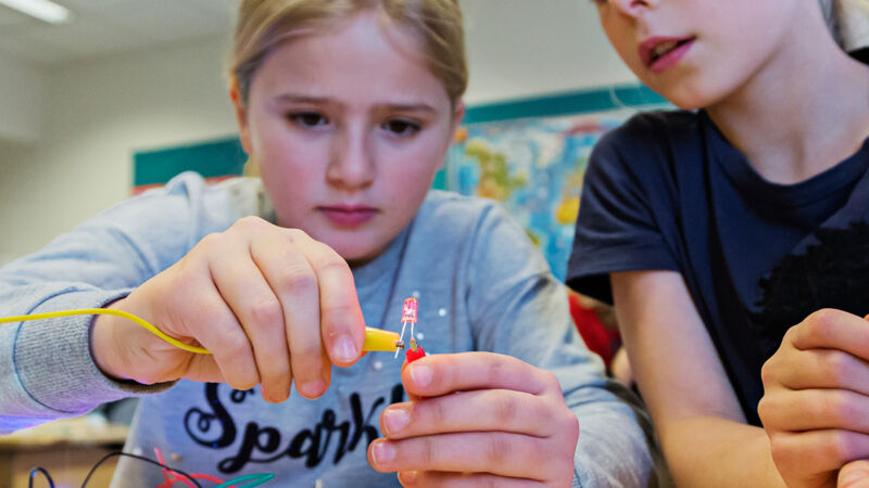 två tjejer bygger en konstruktion med kablar