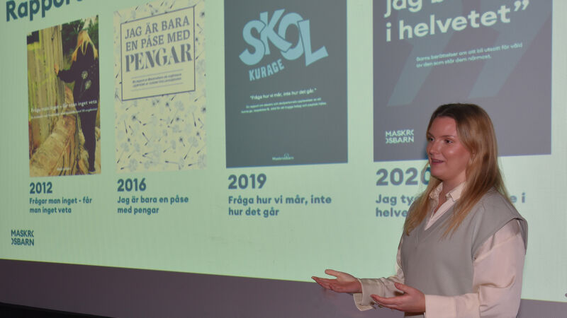 Kvinna som står och föreläser med vid en projektor -duk