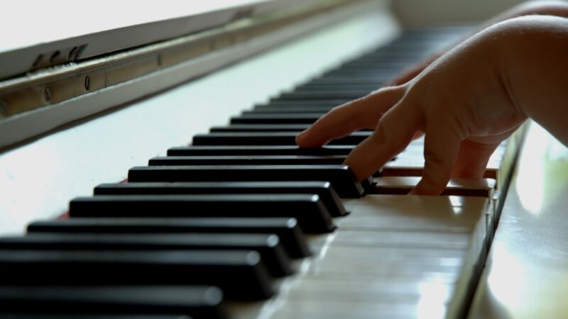 ett barns hand spelar pianot