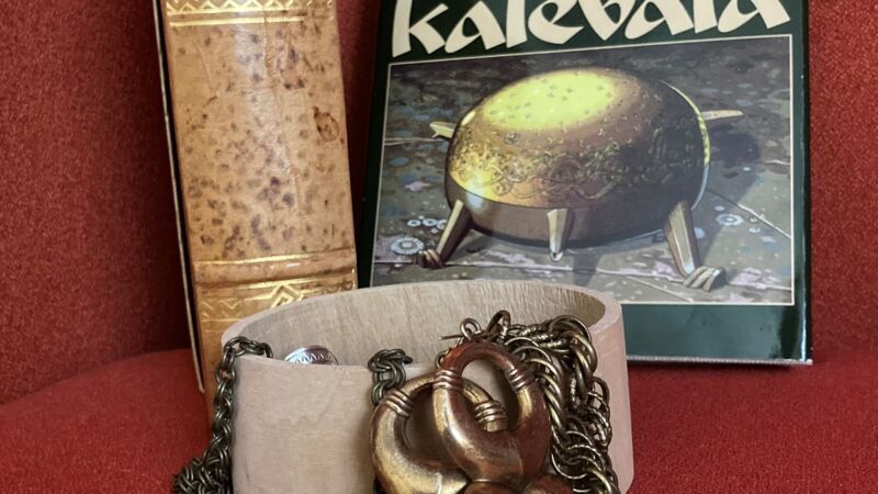 smycken ligger på en röd soffa med boken bakom
