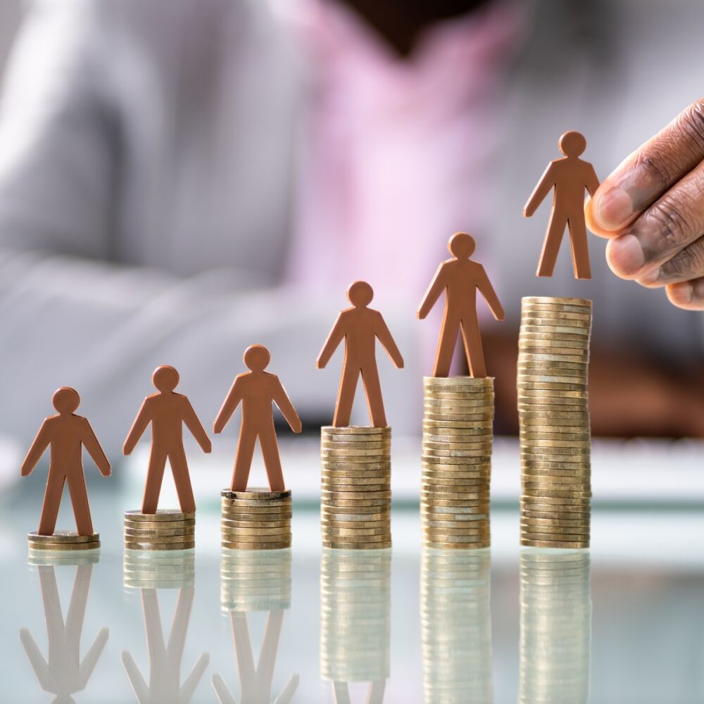 en kvinnligt hand sätter upp mynt och små figurer