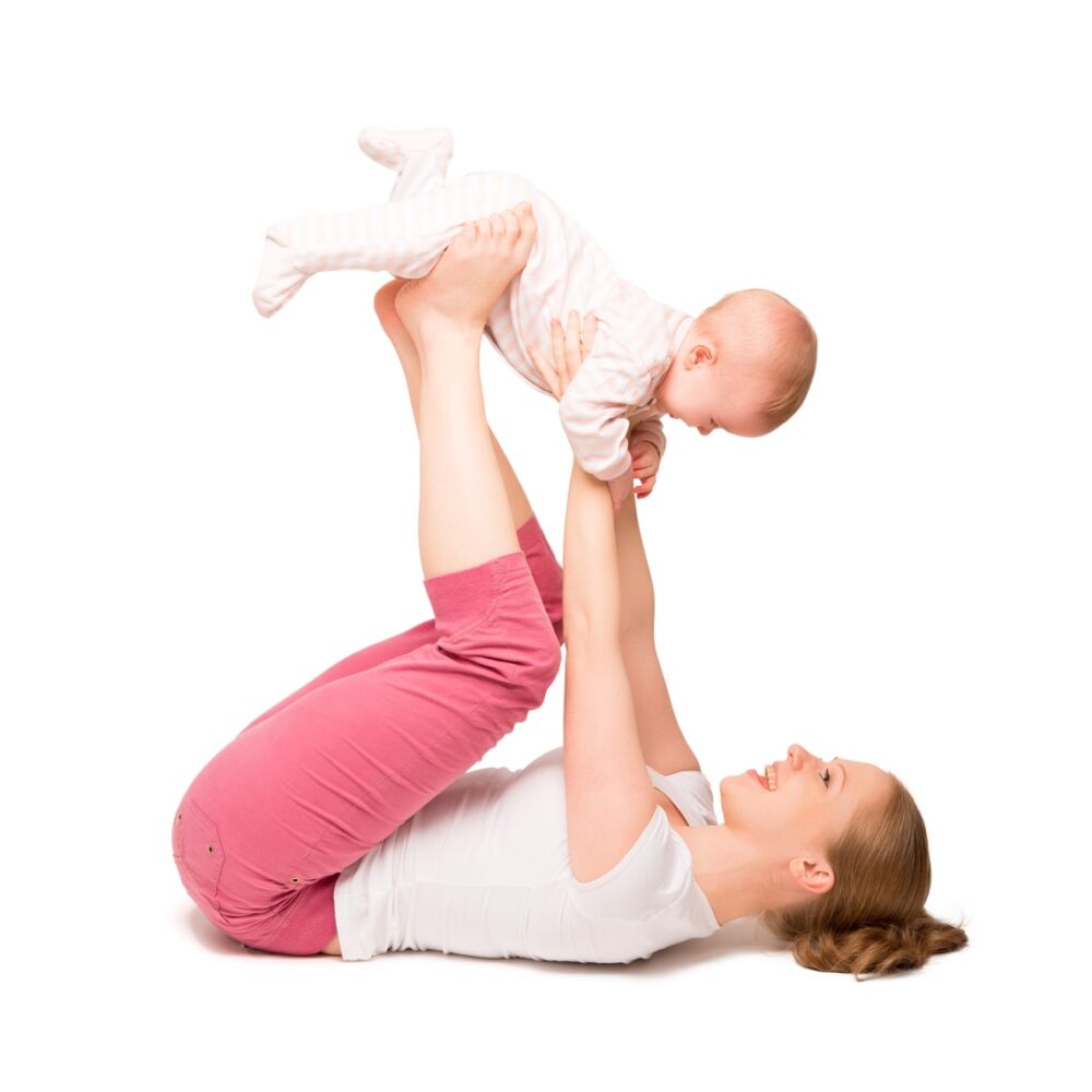 en ung kvinna ligger på golvet och håller bebis