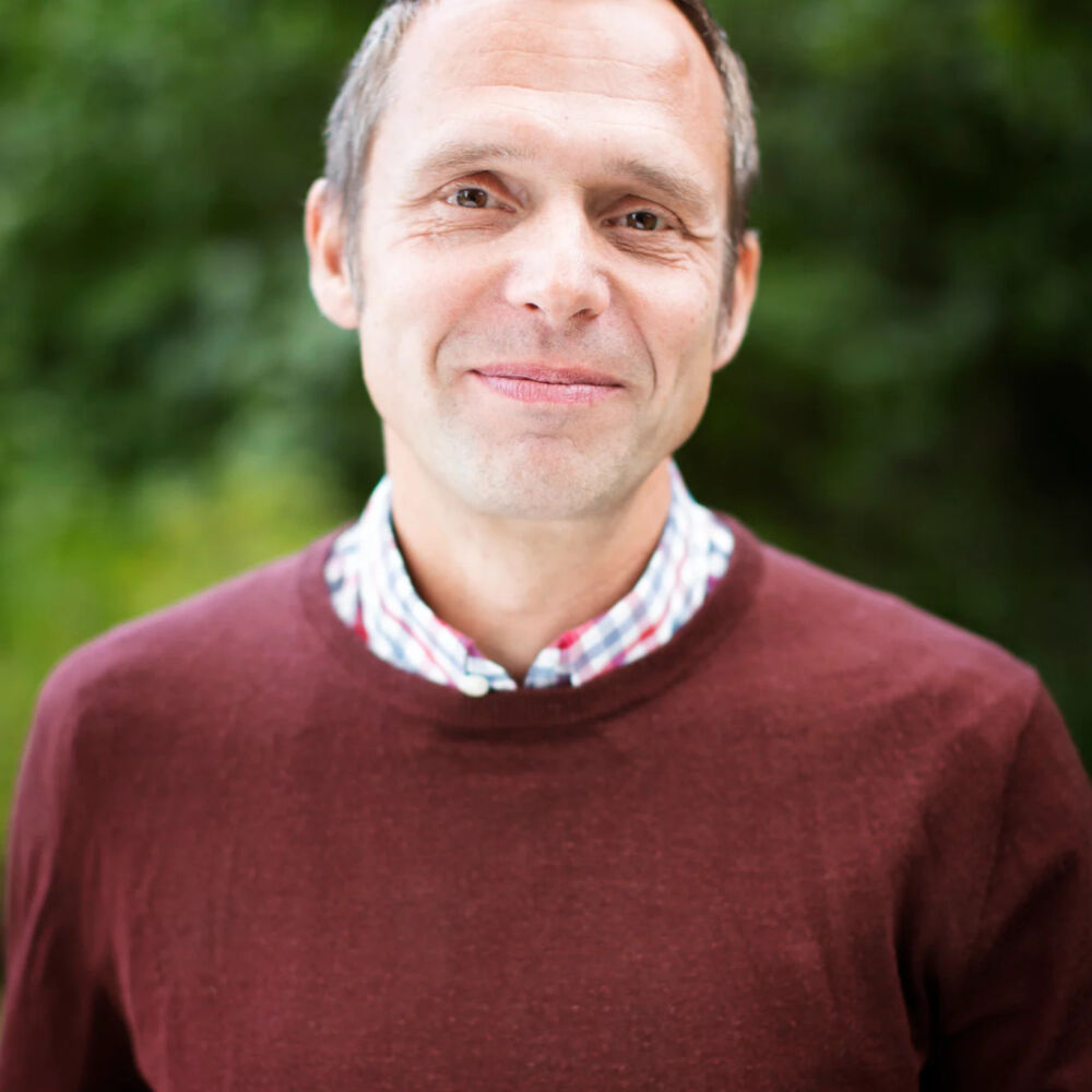 Bild på Jens Holm med vinröd tröja.