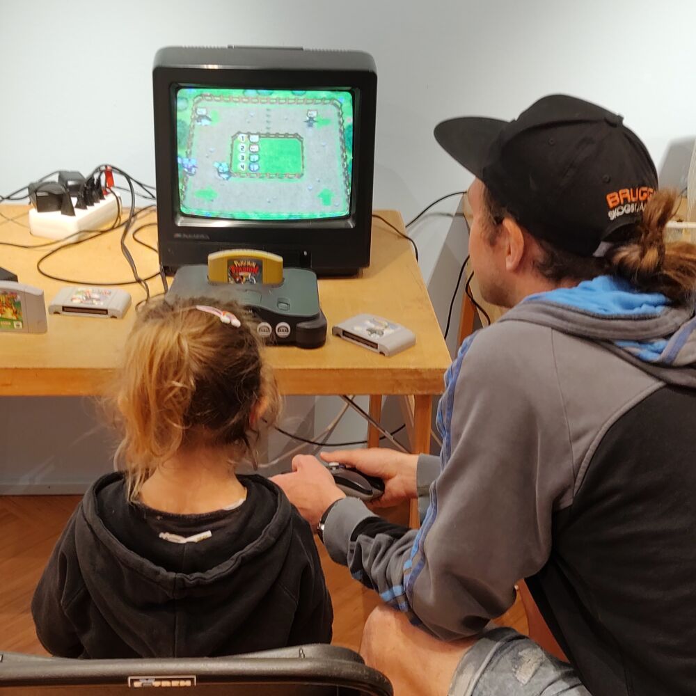 Flicka och kille sitter och spelar äldre dataspel