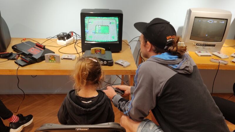 Flicka och kille sitter och spelar äldre dataspel