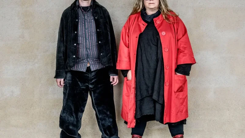 Man och kvinna står mot betongvägg