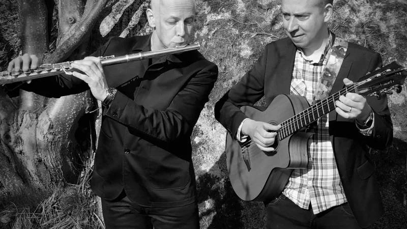 svart-vit bild på två män . Den ena tvärflöjt och den andra gitarr.
