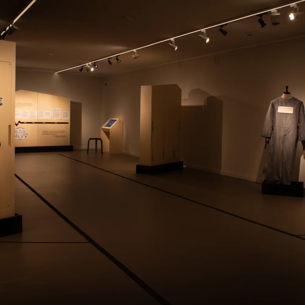Ett rum med utställningsväggar som visar bilder och videos.