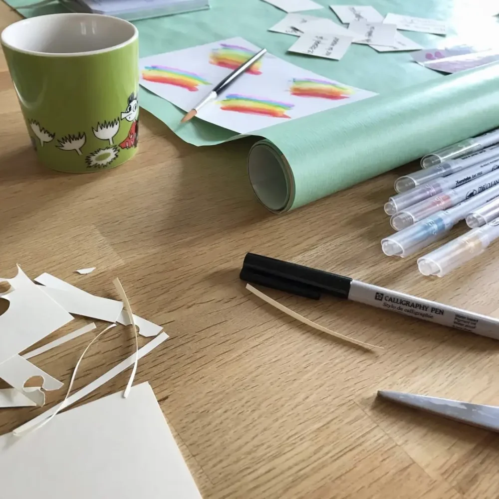 papperspyssel, penna och papper på ett bord