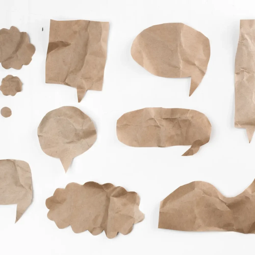 pappersfiguer på vit bakgrund, som ska symbolisera dialogrutor