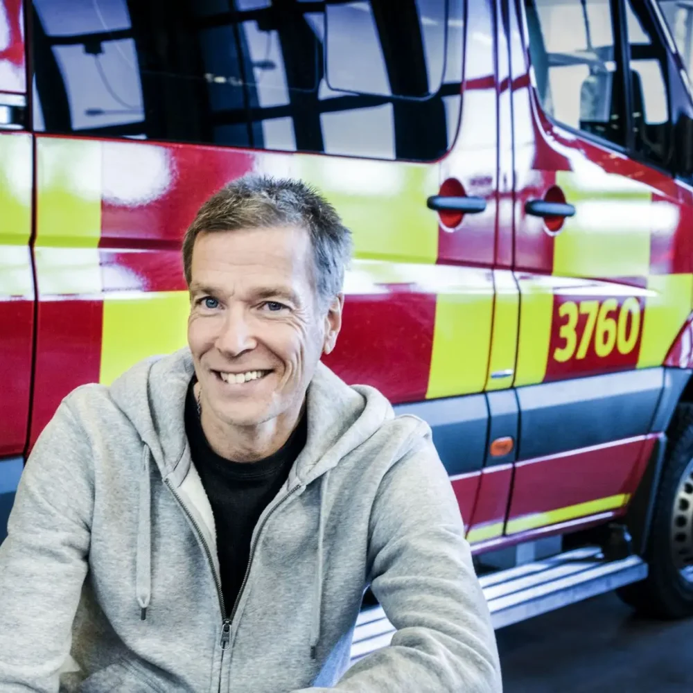 Bild på Johan Anderblad. Glad man framför brandbil